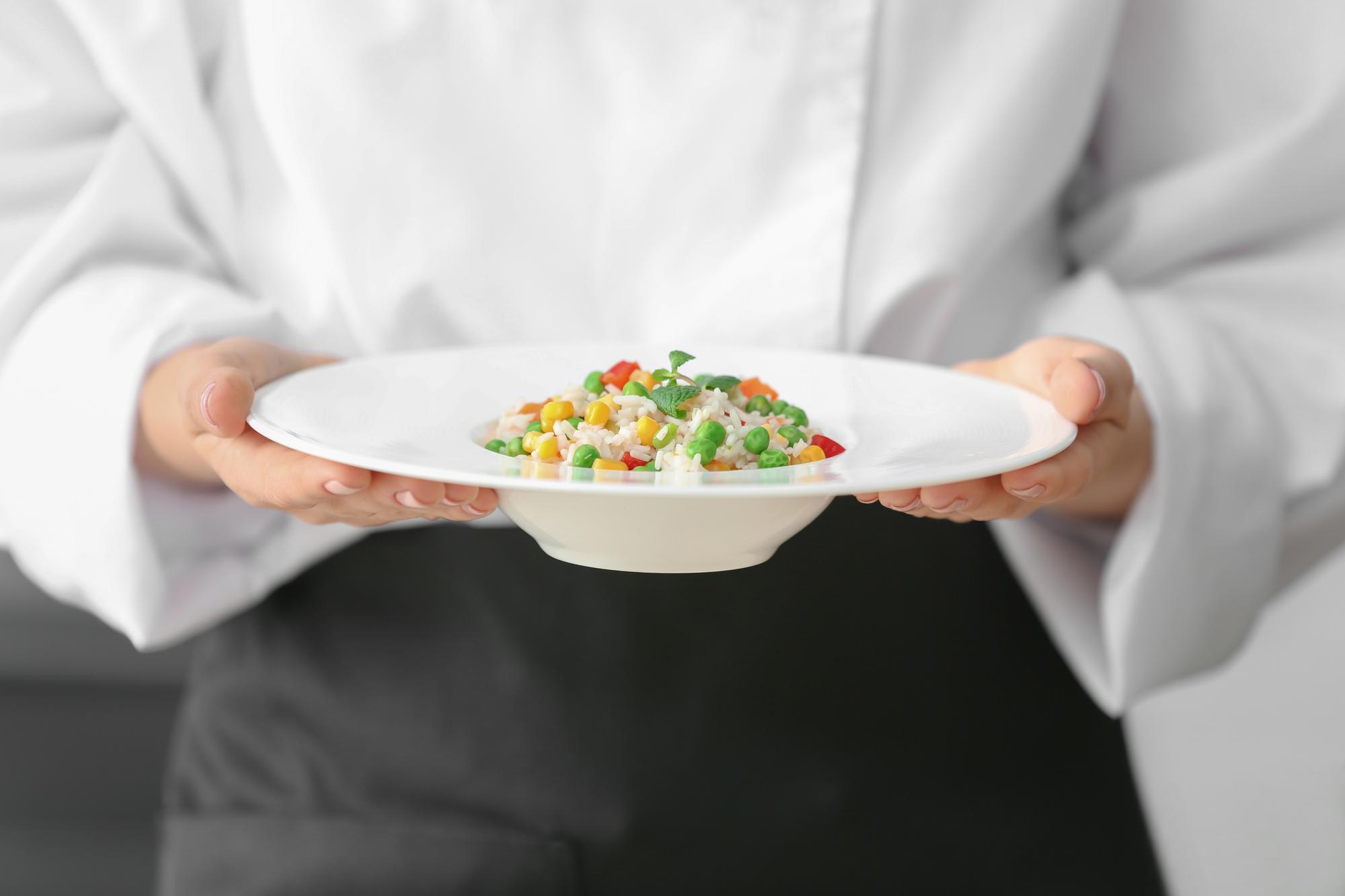 Chef handing over a plated dish to a guest